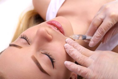 Güzel kadın bir enjeksiyon dudaklarını içinde alır..