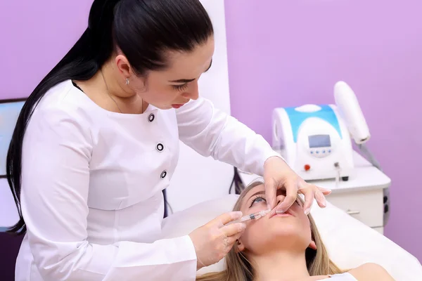 Schöne Frau bekommt eine Spritze in die Lippen. — Stockfoto