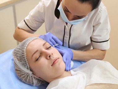 Mezoterapi. Güzel kadın bir enjeksiyon yüzüne alır..