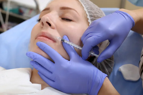 Mesotherapy. Beautiful woman gets an injection in her face.