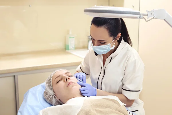 Mesoterapia. Mulher bonita recebe uma injeção em seu rosto . — Fotografia de Stock
