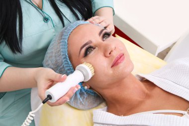 Donanım kozmetolojisi. Deriyi fırçayla temizliyor..