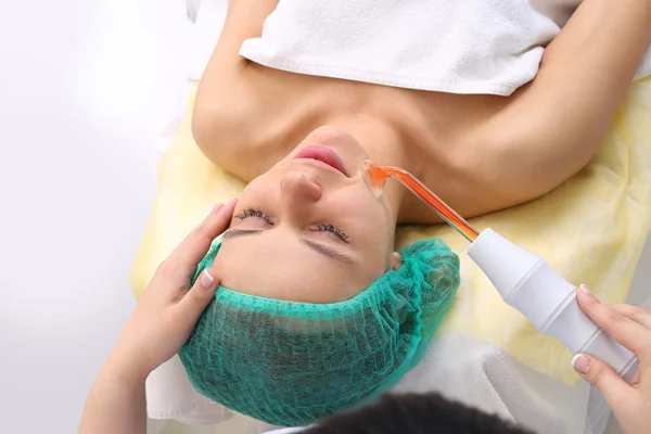 Receiving electric darsonval facial massage procedure. — Stock Photo, Image