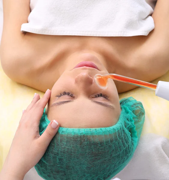 Receiving electric darsonval facial massage procedure. — Stock Photo, Image