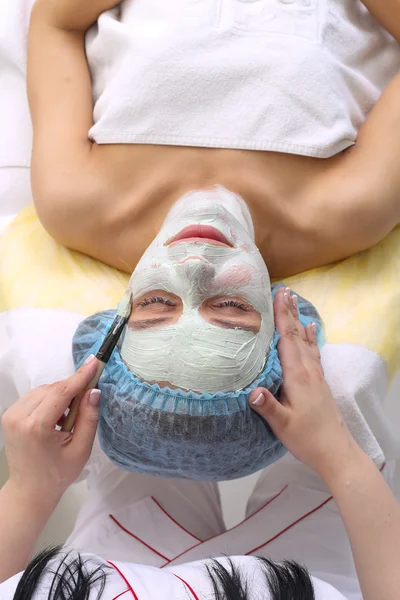 Woman with clay facial mask in beauty spa. — Stock Photo, Image