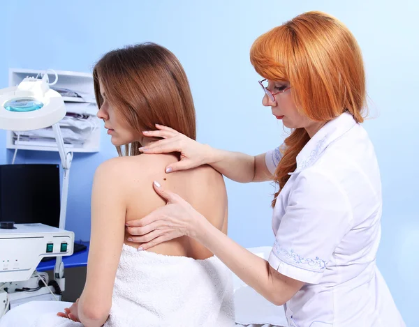 Doktor kadın hastanın cilt inceliyor