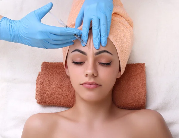 Beautiful woman gets an injection in her face. — Stock Photo, Image