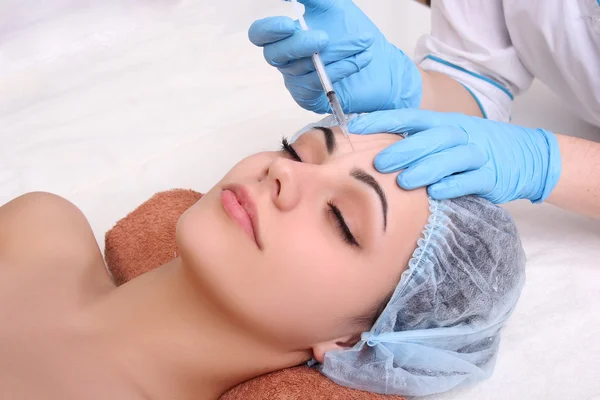 Beautiful woman gets an injection in her face. — Stock Photo, Image