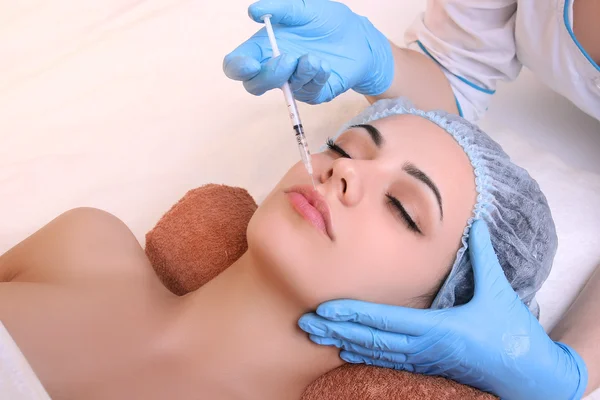 Mulher bonita recebe uma injeção em seu rosto . — Fotografia de Stock