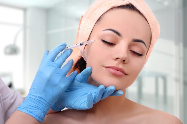 Mooie vrouw krijgt een injectie in haar gezicht. — Stockfoto