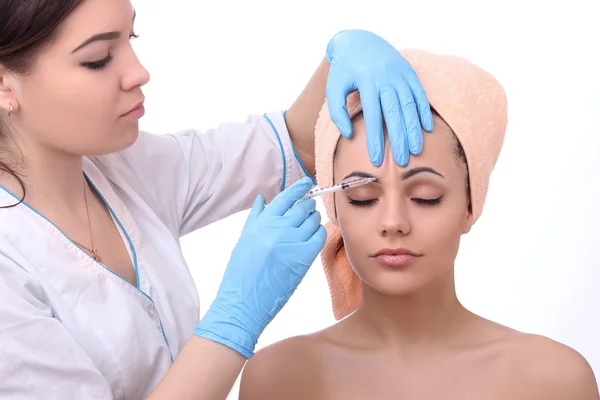 Beautiful woman gets an injection in her face. — Stock Photo, Image