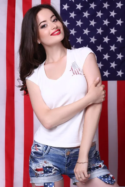 Sexy junge Frau posiert über amerikanischer Flagge Hintergrund — Stockfoto