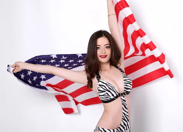 Sexig ung kvinna poserar över amerikanska flaggan bakgrund — Stockfoto