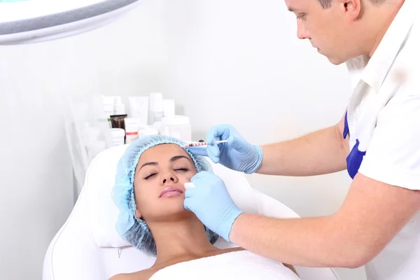 Beautiful woman gets an injection in her face. — Stock Photo, Image