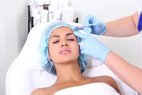 Beautiful woman gets an injection in her face. — Stock Photo, Image