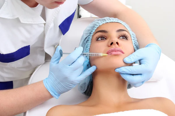 Beautiful woman gets an injection in her lips. — Stock Photo, Image