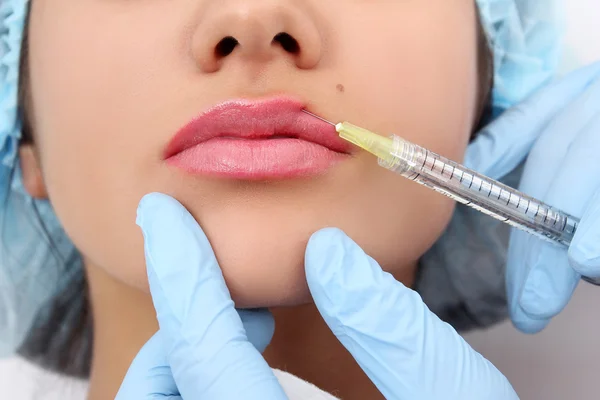 Hermosa mujer recibe una inyección en sus labios . — Foto de Stock