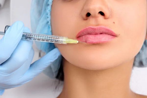 Beautiful woman gets an injection in her lips. — Stock Photo, Image