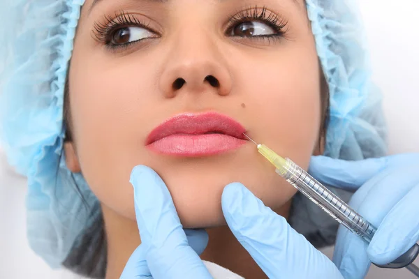 Hermosa mujer recibe una inyección en sus labios . — Foto de Stock