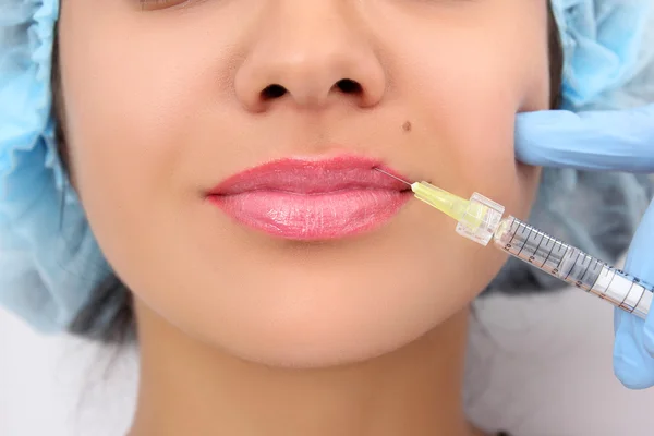 Hermosa mujer recibe una inyección en sus labios . — Foto de Stock