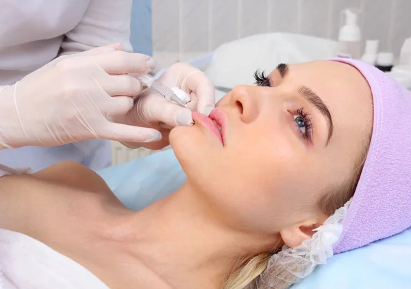 Beautiful woman gets an injection in her lips. — Stock Photo, Image