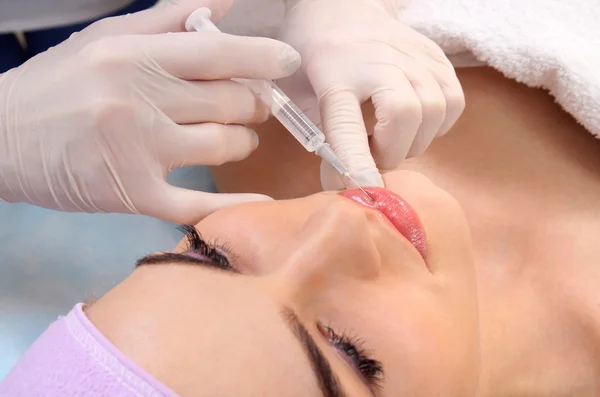 Beautiful woman gets an injection in her lips. — Stock Photo, Image