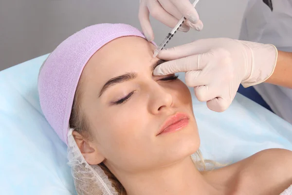 Schöne Frau bekommt eine Spritze ins Gesicht. — Stockfoto