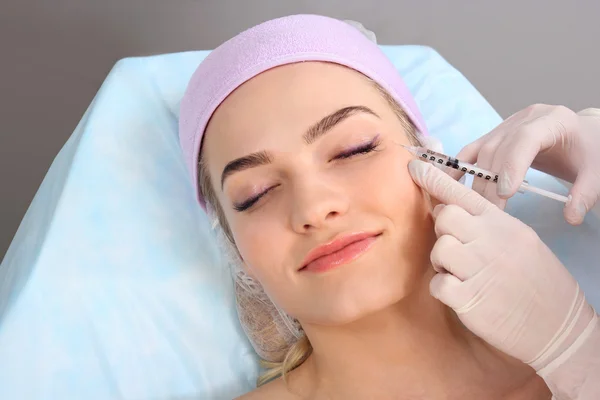 Mulher bonita recebe uma injeção em seu rosto . — Fotografia de Stock