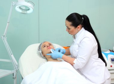 Güzel kadın bir enjeksiyon dudaklarını içinde alır..