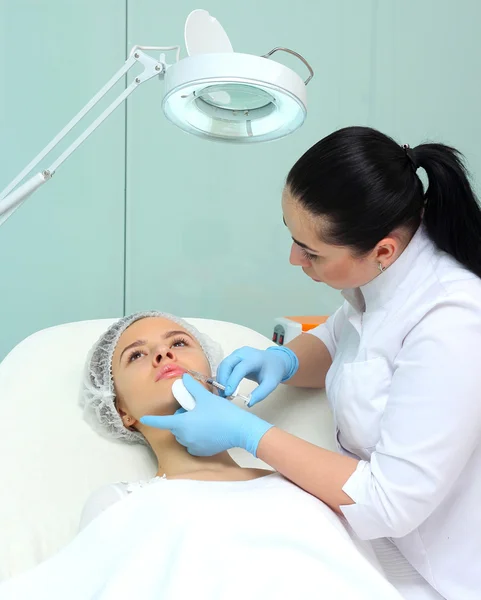 Schöne Frau bekommt eine Spritze in die Lippen. — Stockfoto