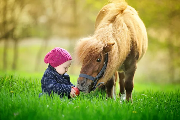 Bambina con mela rossa e pony — Foto Stock