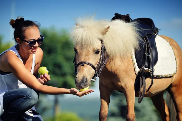 Молодая девушка с пони-паломино — стоковое фото