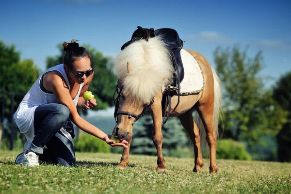 Giovane ragazza con pony palomino — Foto Stock