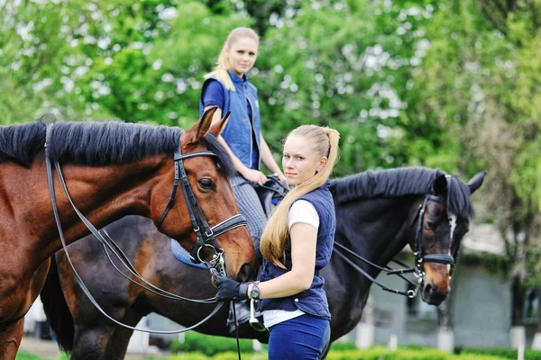 Två unga flickor - dressyrryttare med hästar — Stockfoto