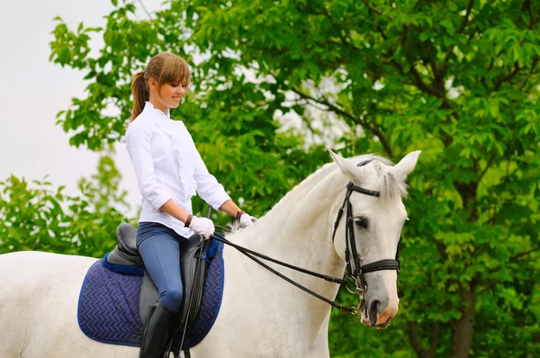 Fille sur cheval de dressage blanc — Photo