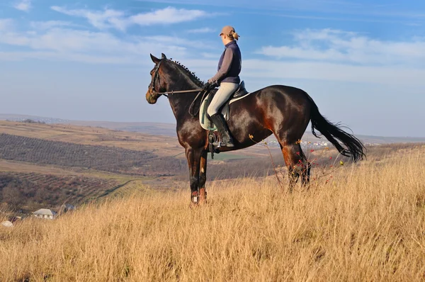Jeune femme chevauchant un cheval en automne classé Images De Stock Libres De Droits