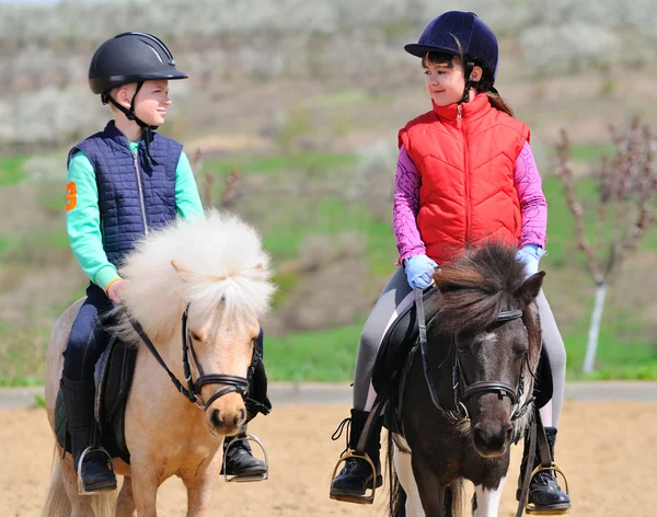 Ragazzo e ragazza cavalcando un pony — Foto Stock