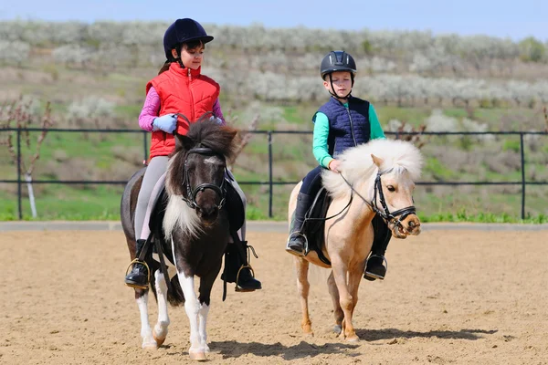 Garçon et fille monter un poney — Photo