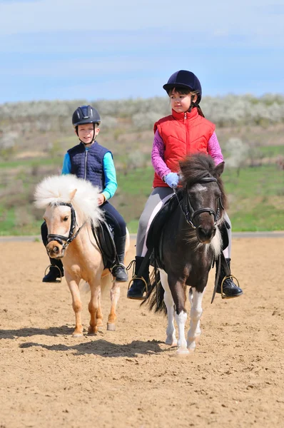 Ragazzo e ragazza cavalcando un pony — Foto Stock