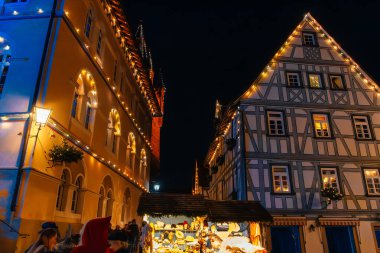Almanya 'nın Bad-Wimpfen kentindeki sıcak ışıklar ve şenlikli atmosferli bir ortaçağ kasabasında Avrupa' nın canlı bir Noel manzarası..