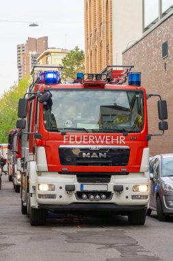 Mannheim, Almanya - 26 Nisan 2023: Tipik bir Alman şehrinde yol üzerinde duran bir Alman itfaiye aracının ön görüntüsü, kentsel bir ortamda kareye hakim oluyor..