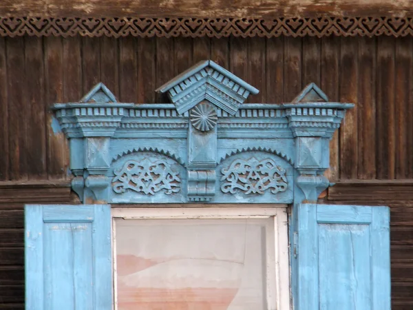 Die Fenster mit schönen Architraven in alten Holzhäusern. ulan lizenzfreie Stockbilder