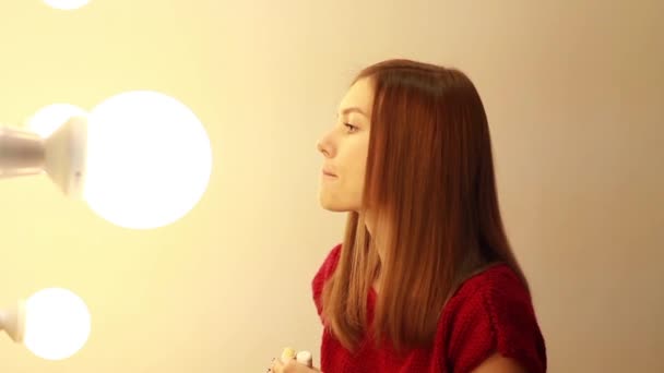 Молодая женщина делает макияж в гримерке . — стоковое видео
