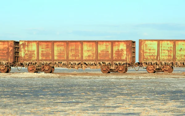 Velhos carros de trem enferrujado com estalactites de sal no lago Baskun — Fotografia de Stock