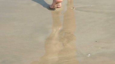 ayak izleri bırakmak kum plajı üzerinde yürüyen kız