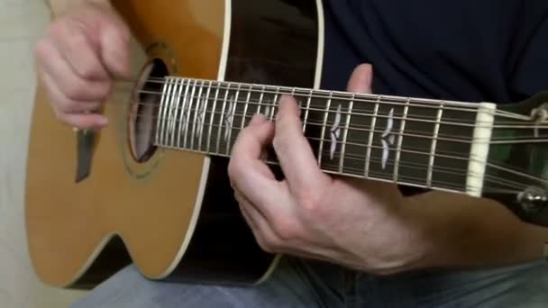 Intérprete tocando la guitarra acústica. Instrumento musical con manos de guitarrista — Vídeos de Stock