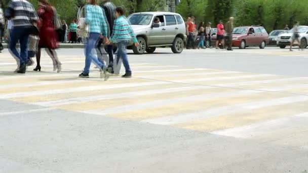 Lidé přecházejí silnici na pěší křižovatce. — Stock video