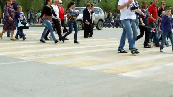 Folk korsar vägen vid en gågata. — Stockvideo