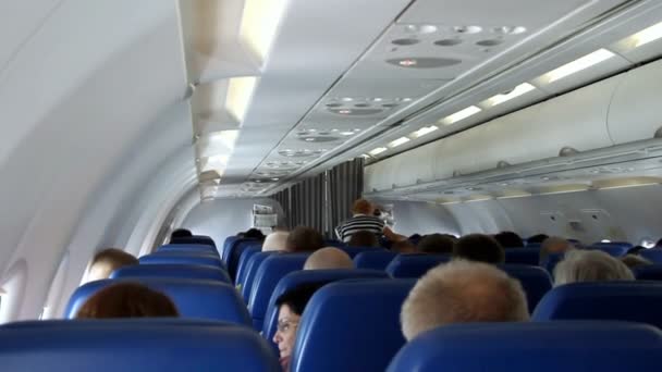 Интерьер самолета с пассажирами на сиденьях. — стоковое видео