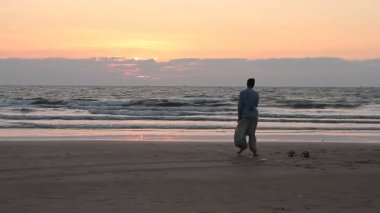 Kimliği belirsiz erkek kumsalda dans. Goa devlet Arambol beach.